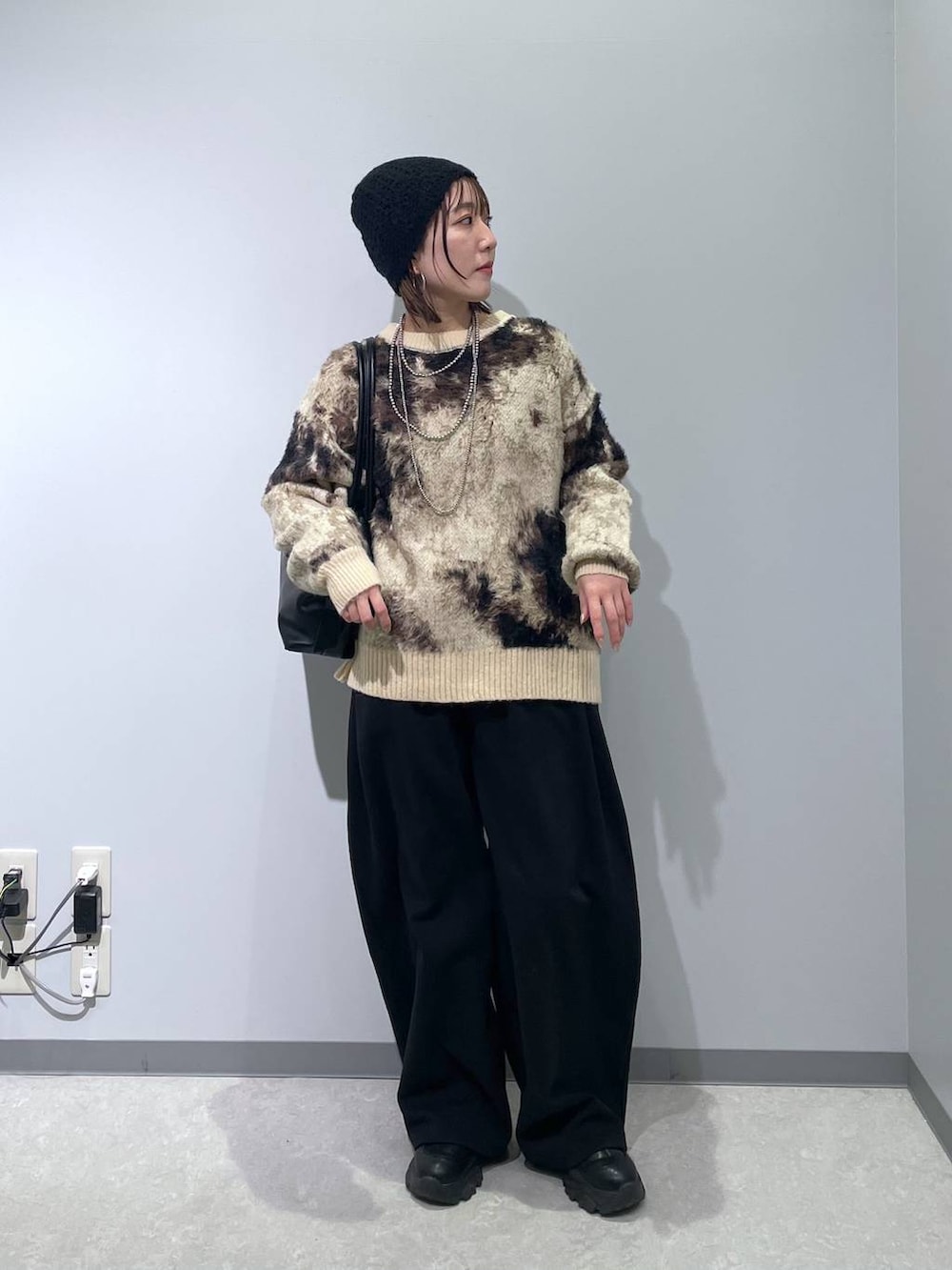 ブラウン系のニット/セーター、ブラック系のボストンバッグ、ブラック系のスウェットパンツを着用したレディースの冬コーディネートの5枚目の写真