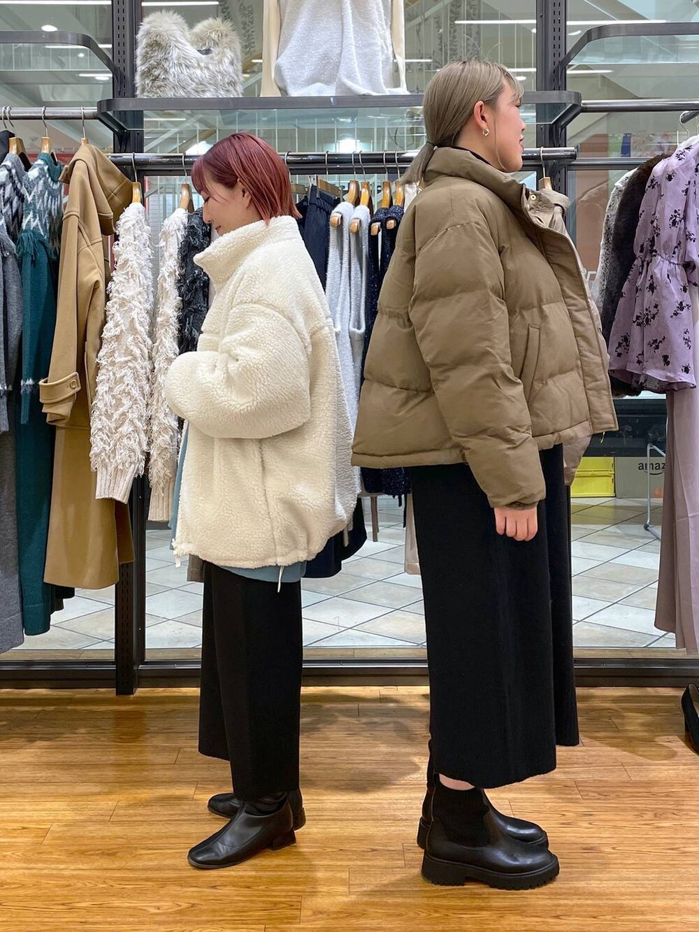 ブラック系のスカート、グリーン系のスウェット、ブラック系のブーツを着用したレディースの冬コーディネートの2枚目の写真