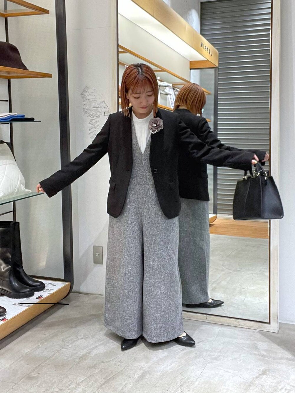 ブラック系のノーカラージャケット、ホワイト系のサロペット/オーバーオール、ホワイト系のシャツ/ブラウスを着用したレディースの冬コーディネートの3枚目の写真