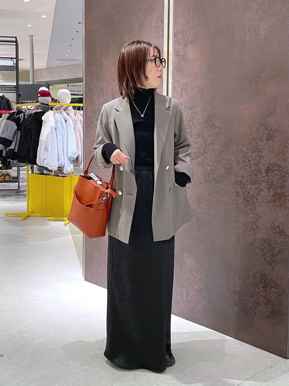 ブラック系のスカート、ブラック系のニット/セーター、レッド系のショルダーバッグを着用したレディースの冬コーディネートの2枚目の写真