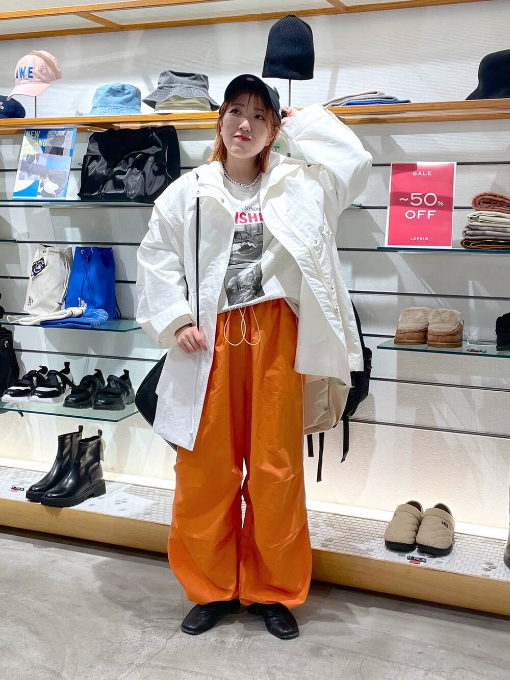 オレンジ系のその他パンツ、ホワイト系のその他アウター、グレー系のTシャツ/カットソーを着用したレディースの春コーディネートの3枚目の写真