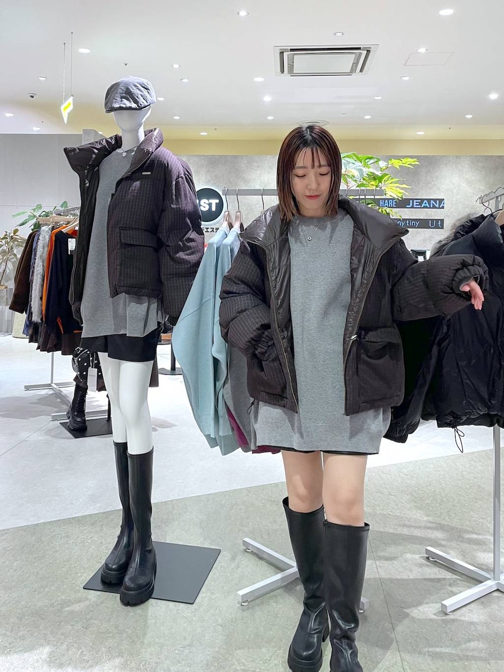 グレー系のニット/セーター、ブラック系のブーツ、ブラウン系のブルゾンを着用したレディースの秋コーディネートの2枚目の写真