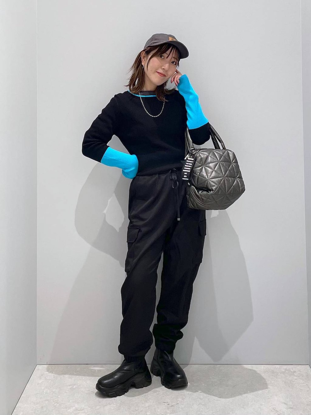 ブラック系のブルゾン、ブラック系のトートバッグ、ブラック系のカーゴパンツを着用したレディースの冬コーディネートの9枚目の写真