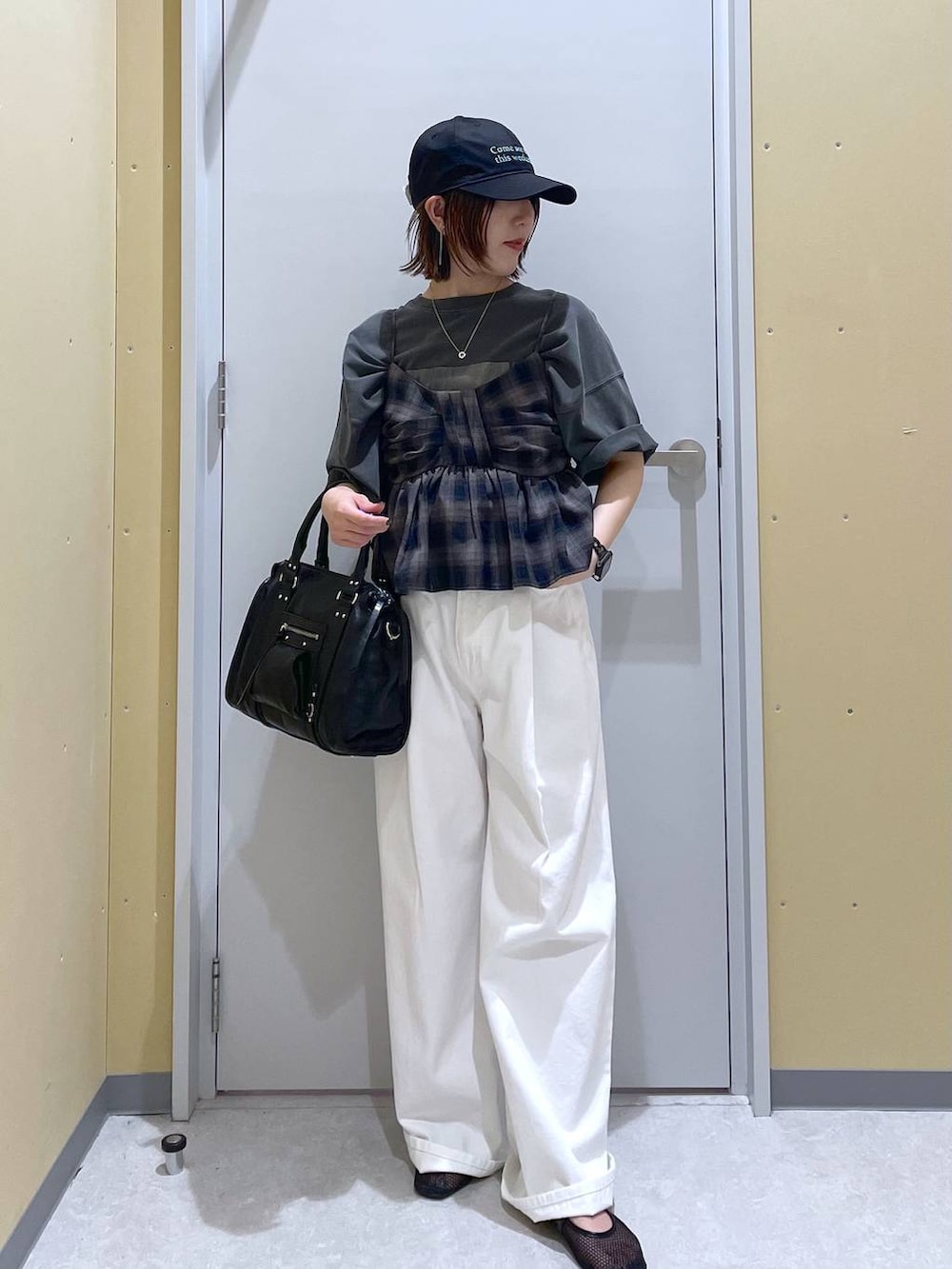 ホワイト系のデニムパンツ、ブラック系のボストンバッグ、グレー系のTシャツ/カットソーを着用したレディースの夏コーディネートの2枚目の写真