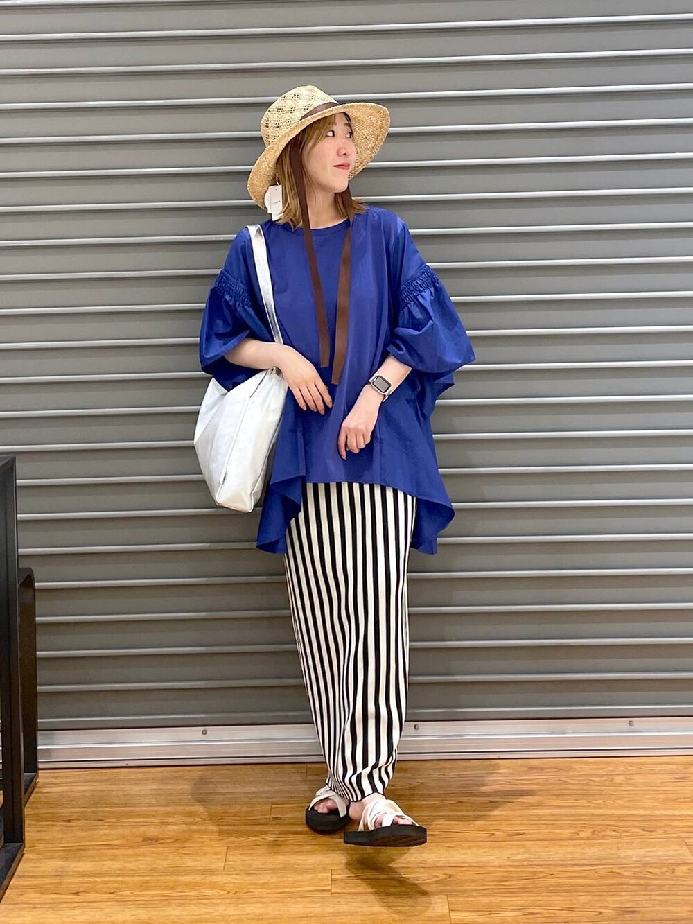 ブルー系のTシャツ/カットソー、ホワイト系のスカート、ホワイト系のサンダルを着用したレディースの夏コーディネートの2枚目の写真