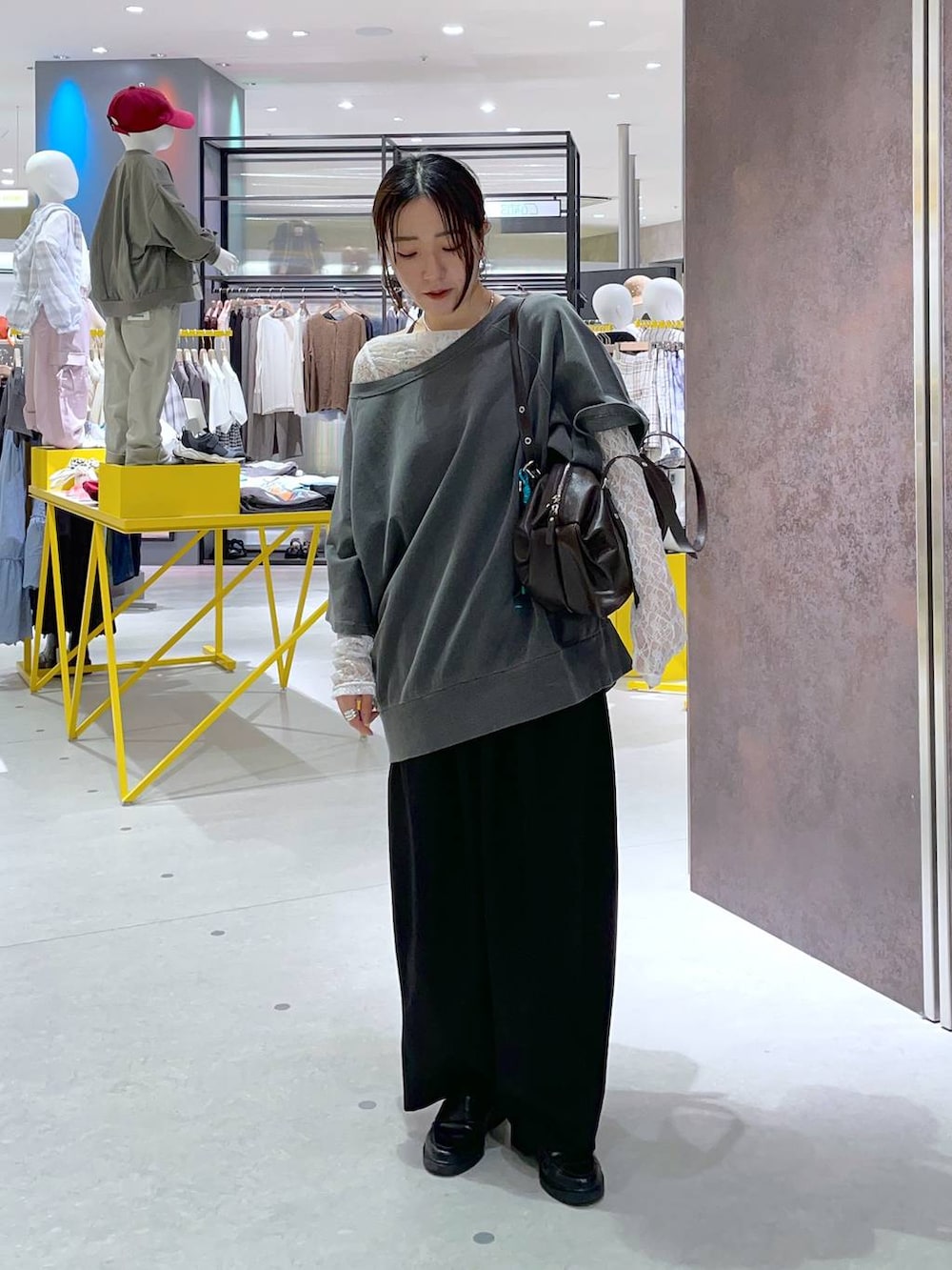ブラック系のスラックス、ホワイト系のTシャツ/カットソー、ブラウン系のボストンバッグを着用したレディースの春コーディネートの3枚目の写真