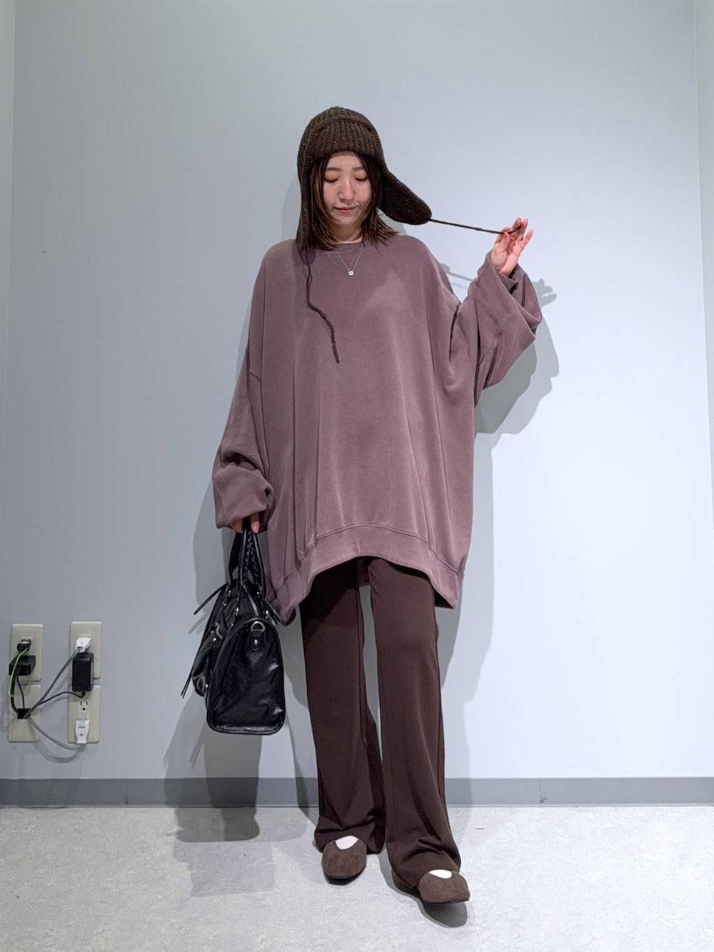 ブラウン系のパンプス、ブラック系のボストンバッグ、ブラウン系のスウェットを着用したレディースの秋コーディネートの2枚目の写真