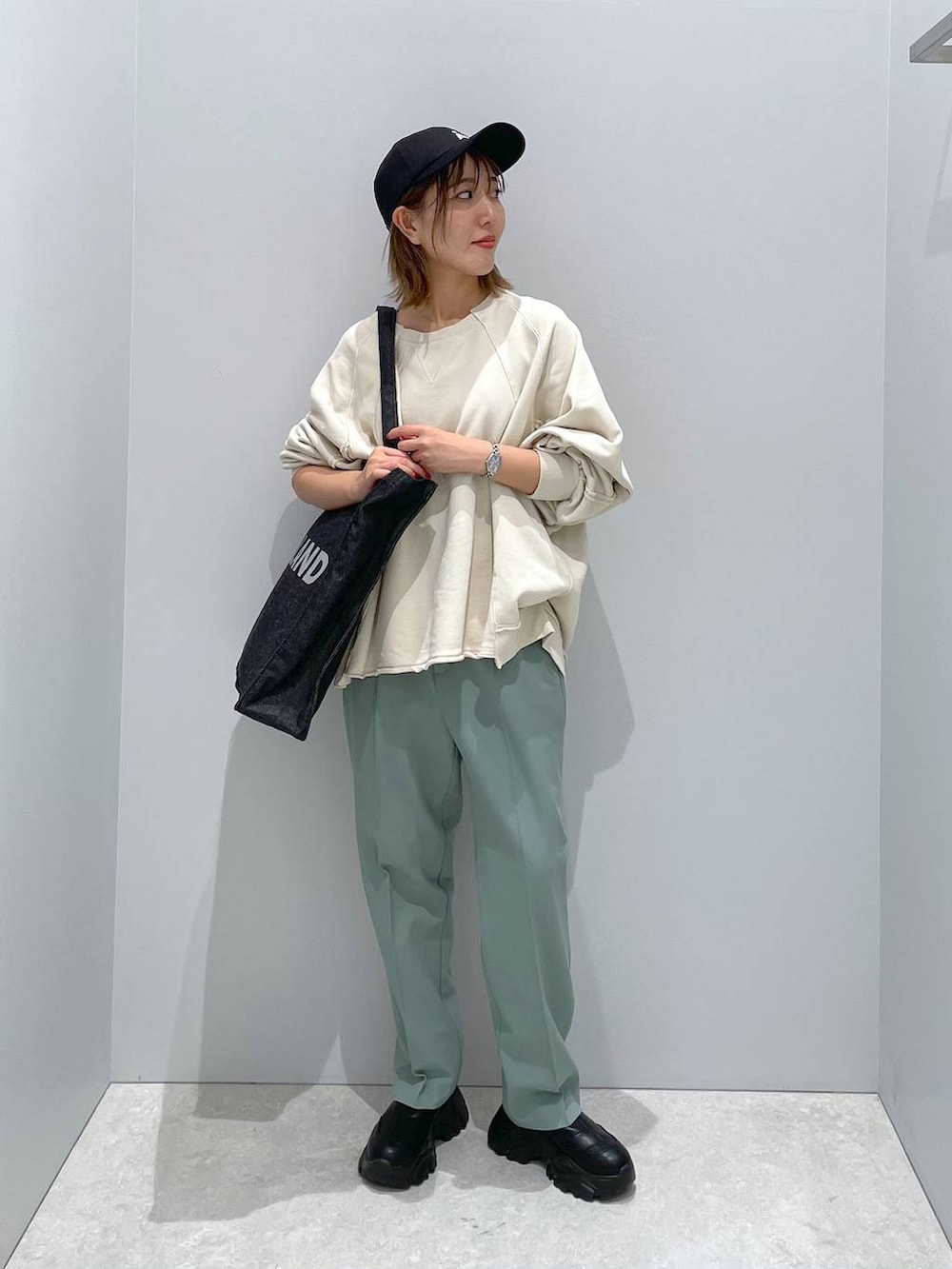 ブラック系のトートバッグ、グリーン系のその他パンツ、ベージュ系のTシャツ/カットソーを着用したレディースの秋コーディネートの2枚目の写真