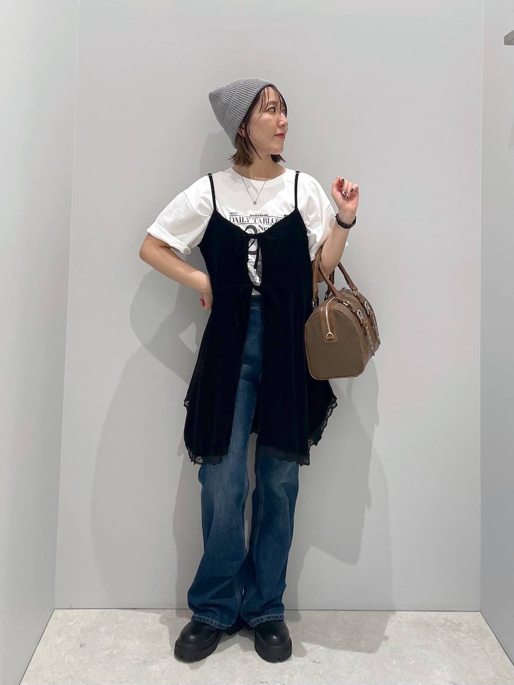 ブルー系のデニムパンツ、グリーン系のボストンバッグ、ホワイト系のTシャツ/カットソーを着用したレディースの秋コーディネートの4枚目の写真