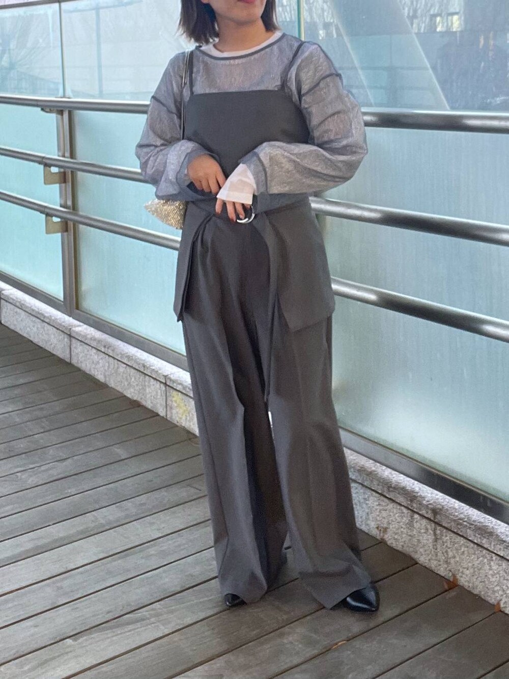 シルバー系のショルダーバッグ、グレー系のキャミソール、ホワイト系のTシャツ/カットソーを着用したレディースの春コーディネートの2枚目の写真