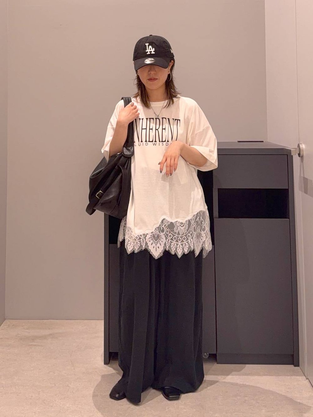 ブラック系のその他パンツ、ブラック系のショルダーバッグ、ホワイト系のTシャツ/カットソーを着用したレディースの夏コーディネートの2枚目の写真