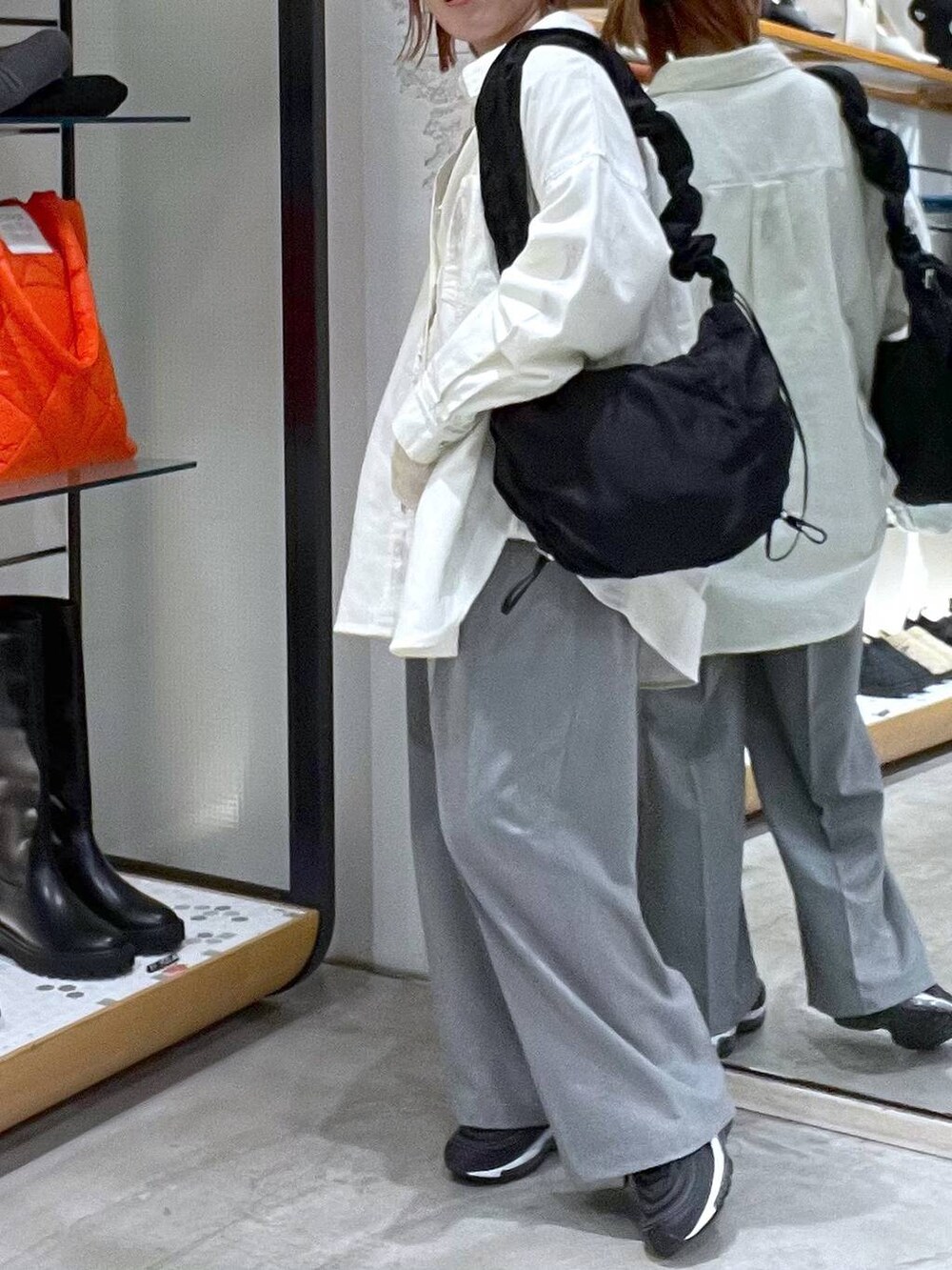 グリーン系のTシャツ/カットソー、ホワイト系のシャツ/ブラウス、ブラック系のショルダーバッグを着用したレディースの春コーディネートの2枚目の写真