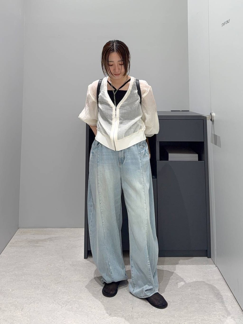 ベージュ系のカーディガン/ボレロ、ブラック系のバックパック/リュック、ブルー系のデニムパンツを着用したレディースの夏コーディネートの2枚目の写真