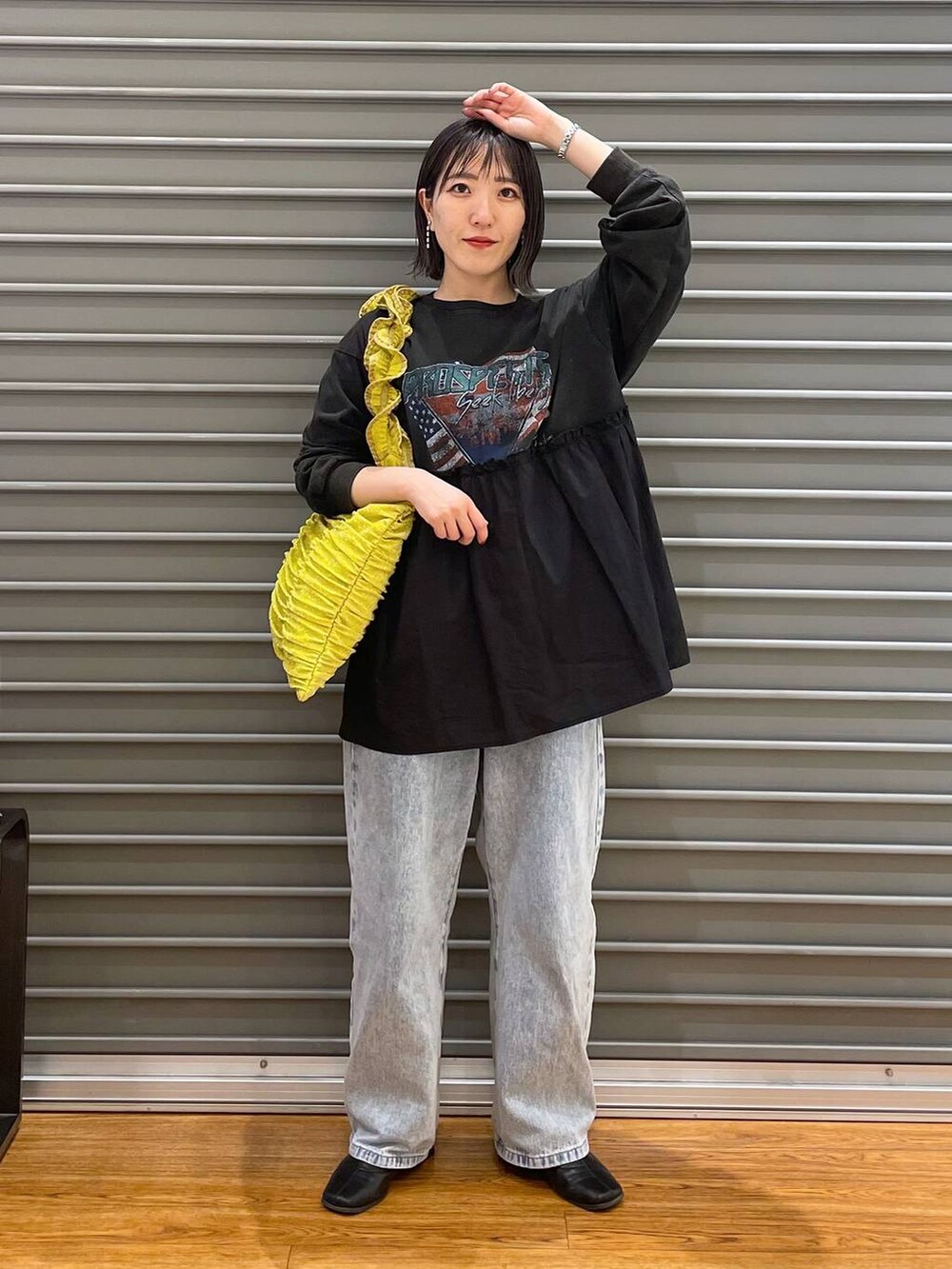 イエロー系のトートバッグ、ブルー系のデニムパンツ、グレー系のTシャツ/カットソーを着用したレディースの春コーディネートの3枚目の写真