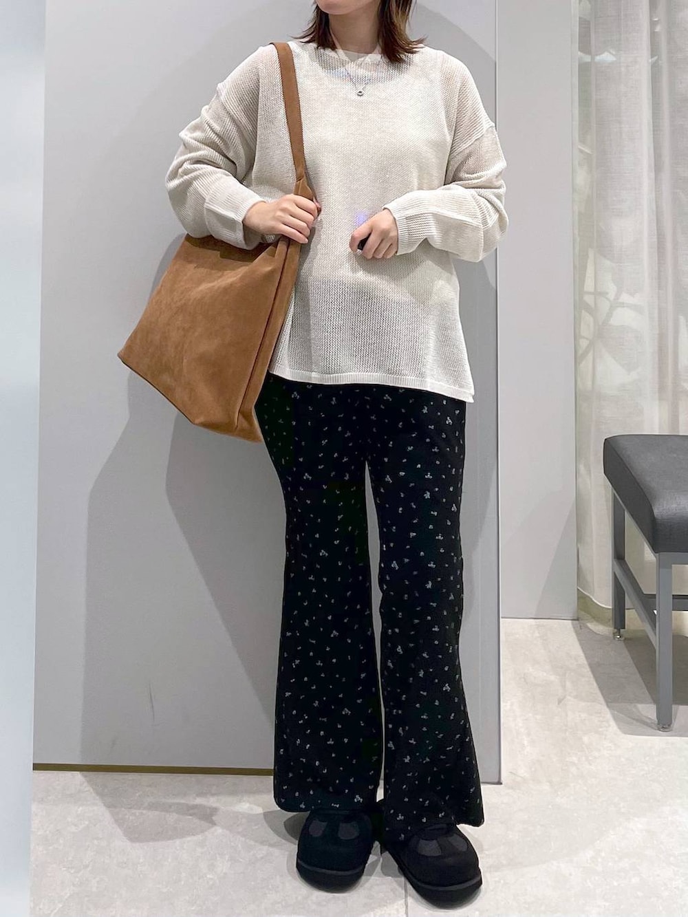 ベージュ系のショルダーバッグ、ホワイト系のニット/セーター、ブラック系のその他パンツを着用したレディースの春コーディネートの2枚目の写真