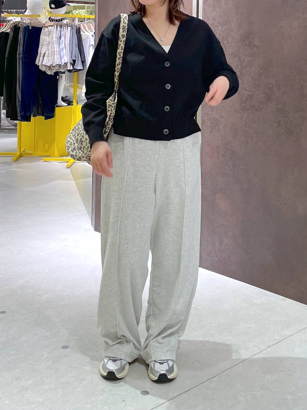 グレー系のその他パンツ、ブラック系のカーディガン/ボレロ、その他のトートバッグを着用したレディースの春コーディネートの2枚目の写真