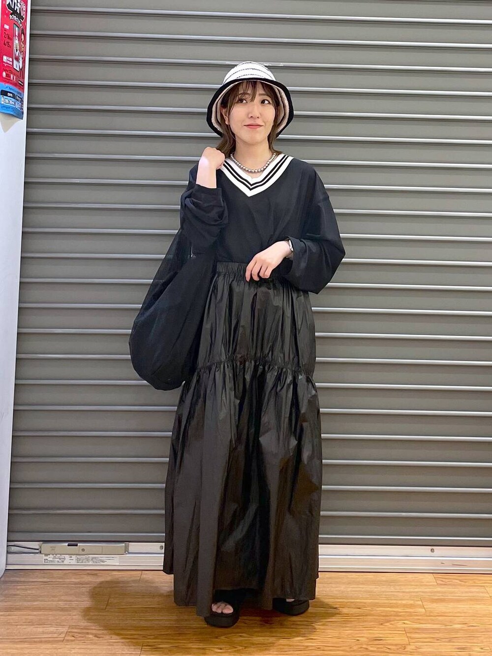 ブラック系のTシャツ/カットソー、ブラック系のショルダーバッグ、ブラック系のサンダルを着用したレディースの春コーディネートの2枚目の写真