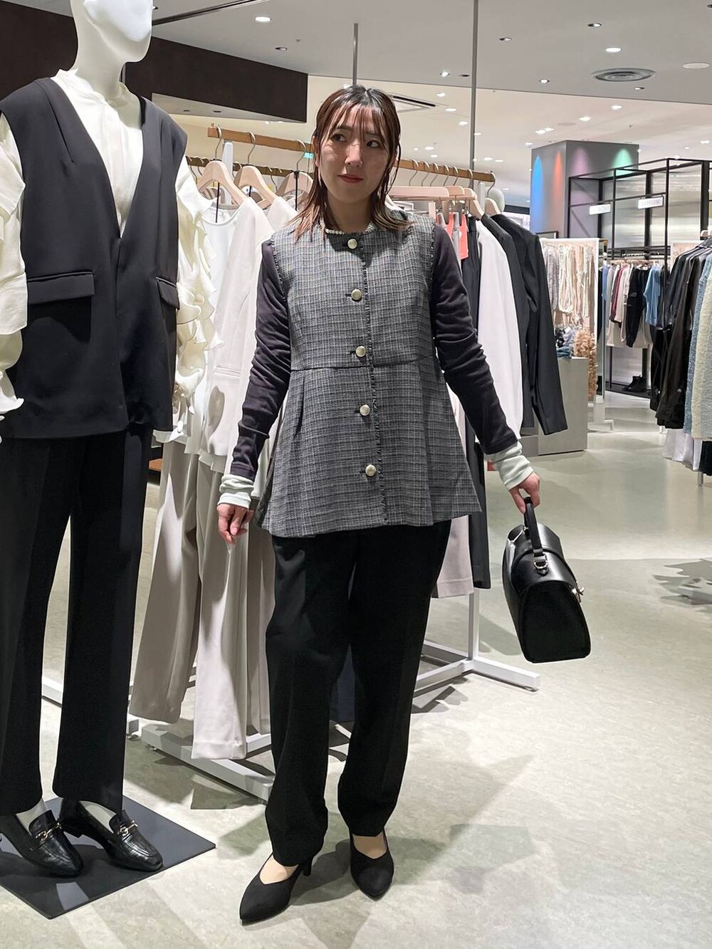 ブラック系のその他パンツ、ブラック系のベスト、ブラック系のショルダーバッグを着用したレディースの冬コーディネートの4枚目の写真