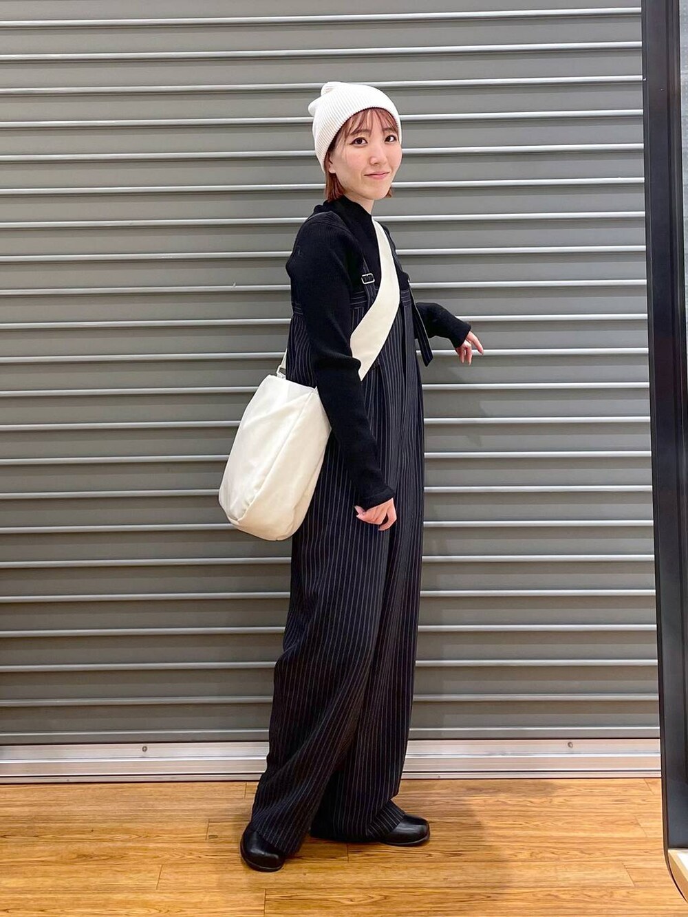 ブラック系のニット/セーター、ホワイト系のショルダーバッグ、ブルー系のその他パンツを着用したレディースの冬コーディネートの3枚目の写真