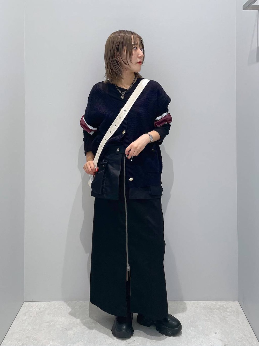 ホワイト系のショルダーバッグ、ブラック系のTシャツ/カットソー、ブラック系のスカートを着用したレディースの秋コーディネートの2枚目の写真