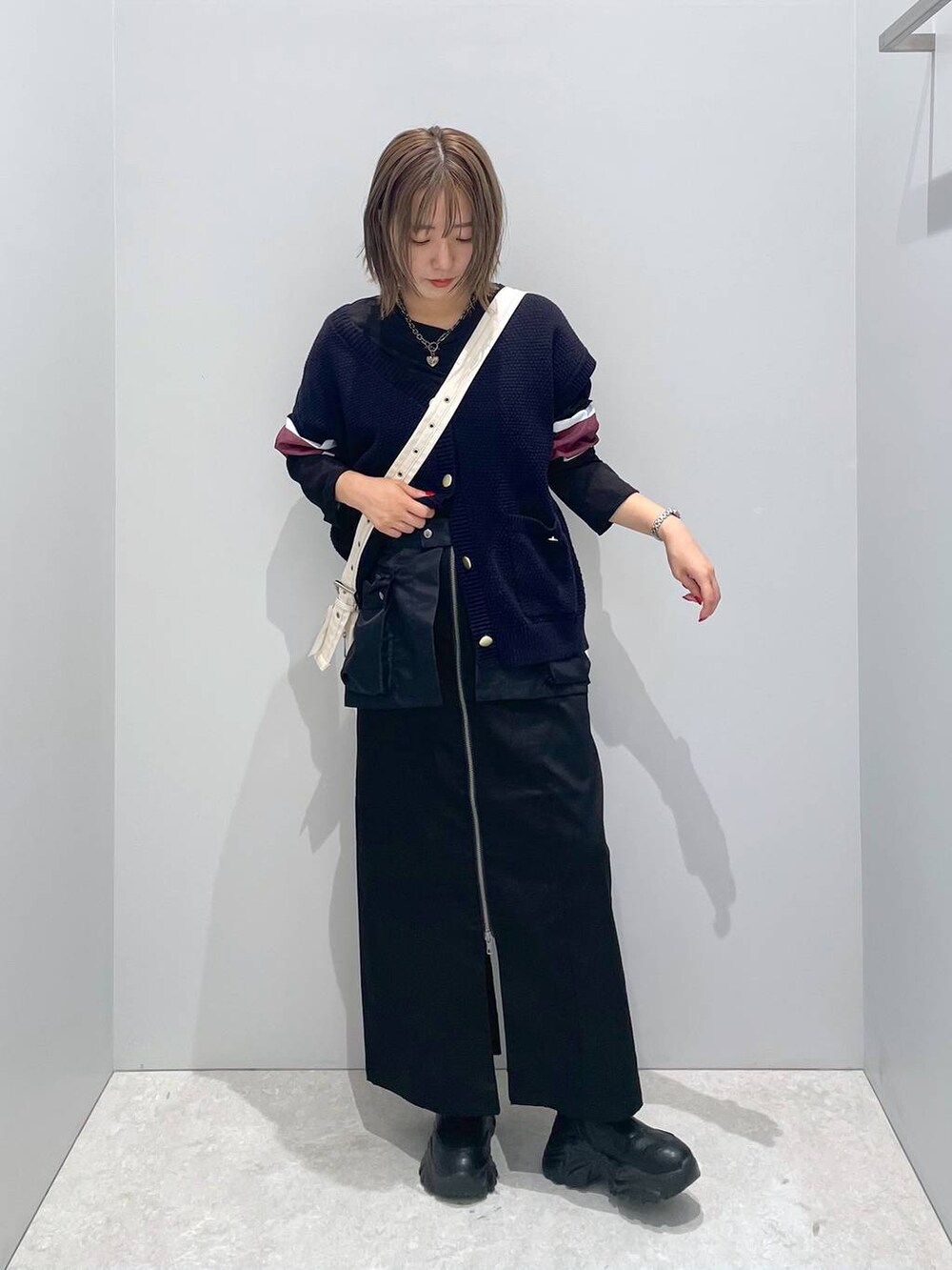 ホワイト系のショルダーバッグ、ブラック系のTシャツ/カットソー、ブラック系のスカートを着用したレディースの秋コーディネートの3枚目の写真
