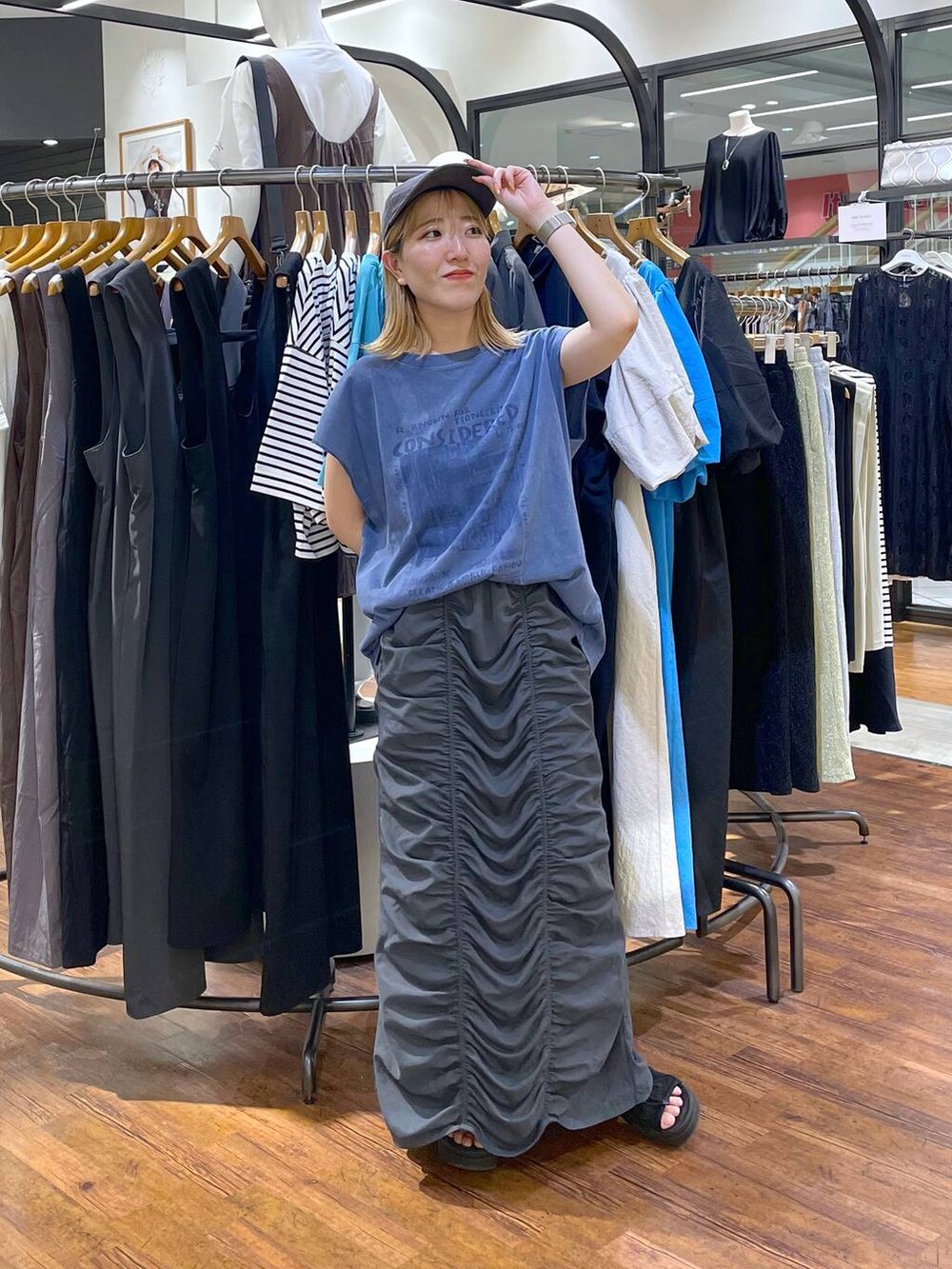 ブルー系のTシャツ/カットソー、グレー系のスカートを着用したレディースの夏コーディネートの2枚目の写真