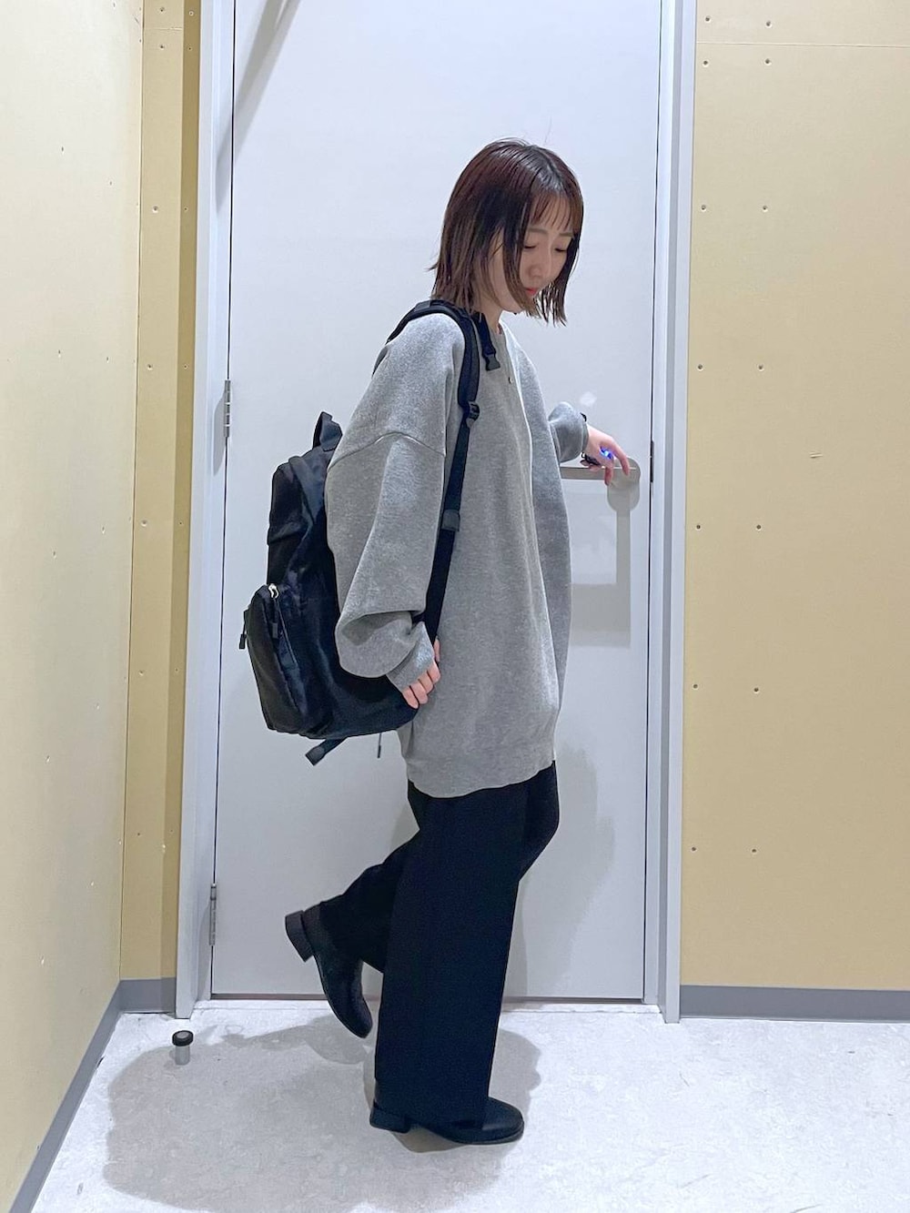 グレー系のニット/セーター、ブラック系のバックパック/リュック、ブラック系のその他パンツを着用したレディースの秋コーディネートの2枚目の写真