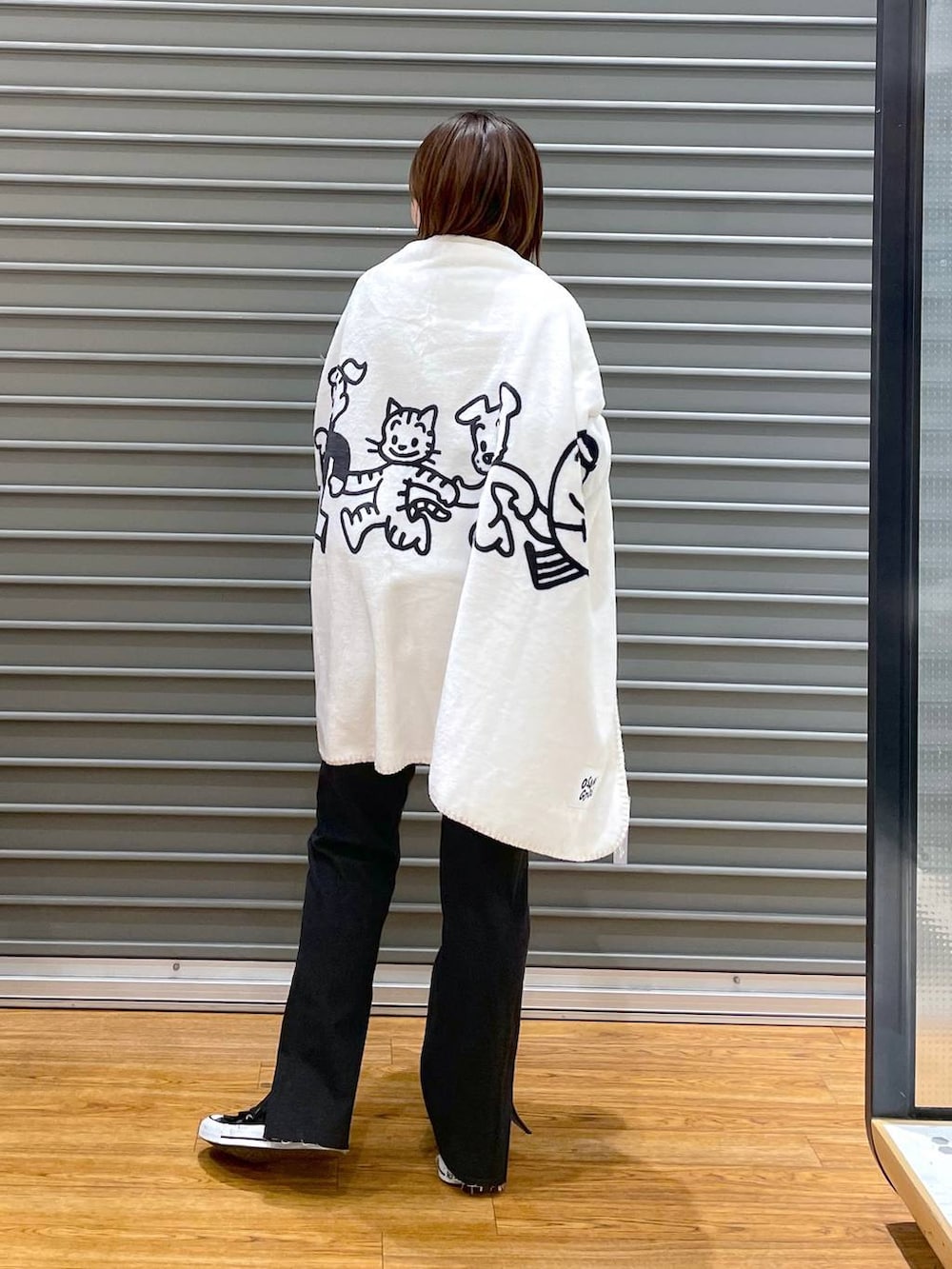 ブラック系のデニムパンツ、グレー系のニット/セーター、ホワイト系のブランケットを着用したレディースの冬コーディネートの2枚目の写真