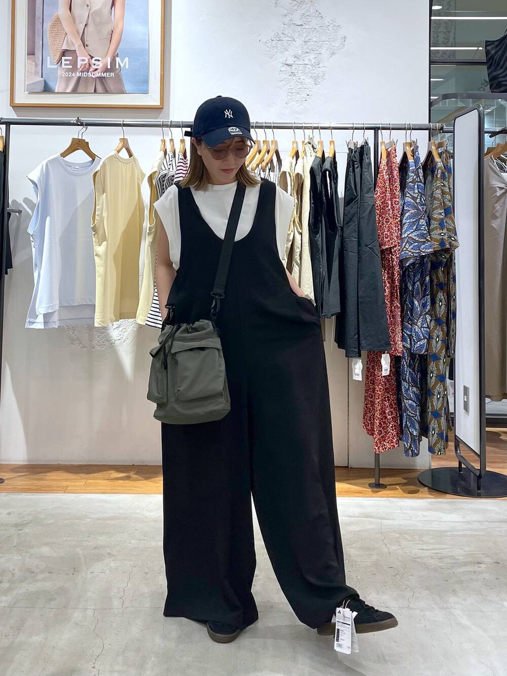 ホワイト系のTシャツ/カットソー、グリーン系のショルダーバッグ、ブラック系のサロペット/オーバーオールを着用したレディースの夏コーディネートの3枚目の写真