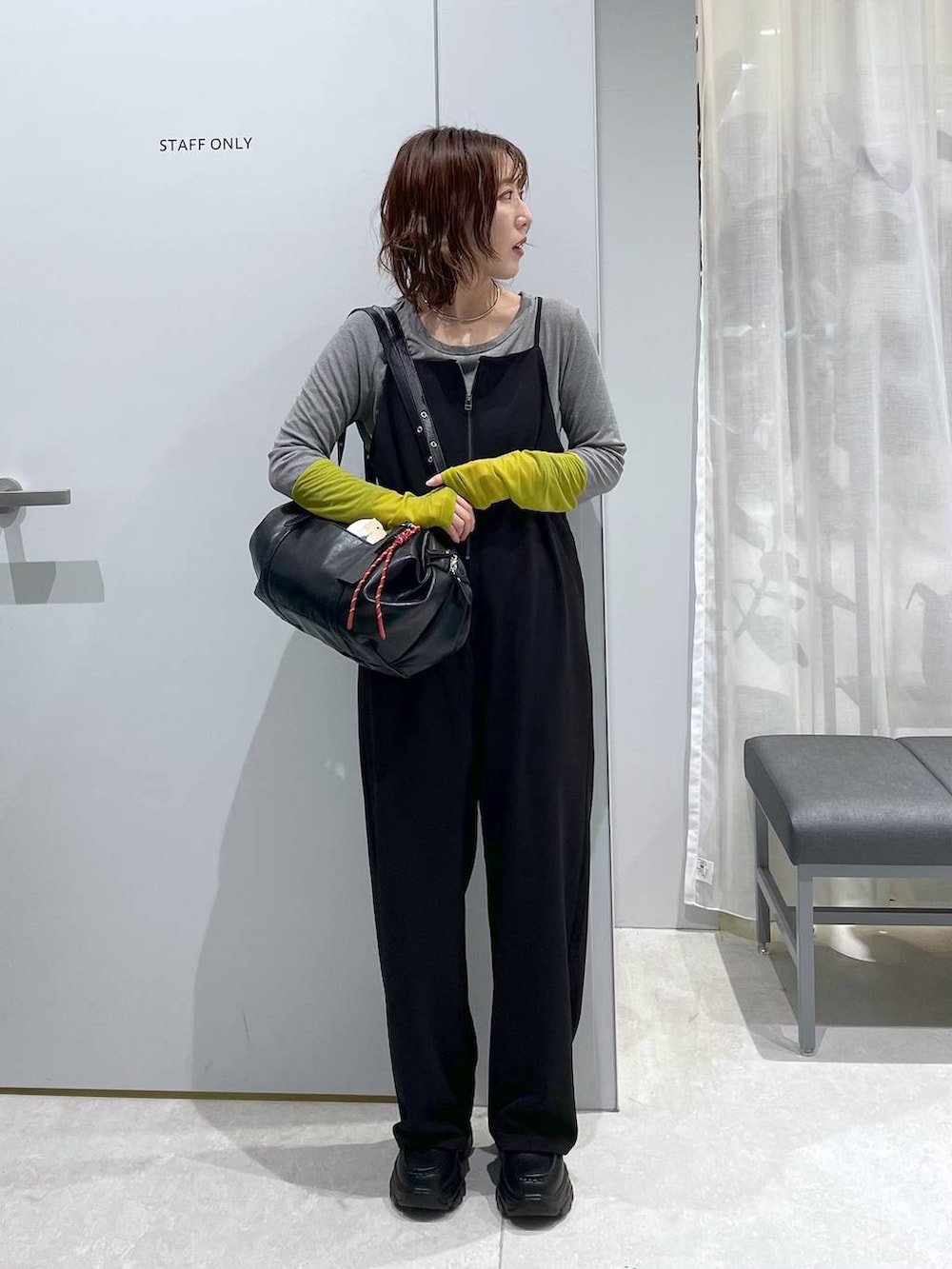 ブラック系のボストンバッグ、ブラック系のローファー、ブラック系のサロペット/オーバーオールを着用したレディースの冬コーディネートの4枚目の写真