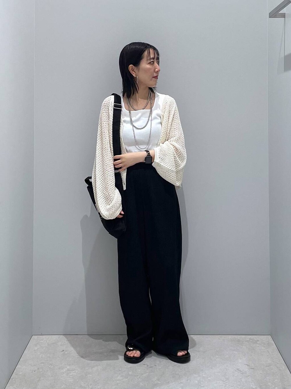 ブラック系のその他パンツ、ホワイト系のタンクトップ、ブラック系のサンダルを着用したレディースの春コーディネートの2枚目の写真