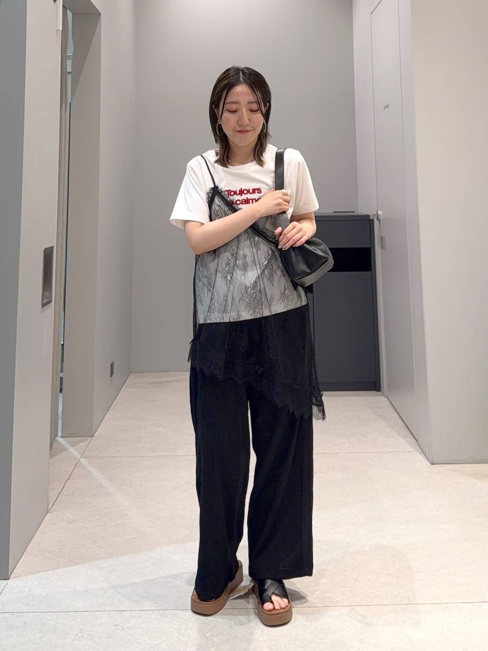 ブラック系のサンダル、ブラック系のショルダーバッグ、ブラック系のその他パンツを着用したレディースの夏コーディネートの3枚目の写真