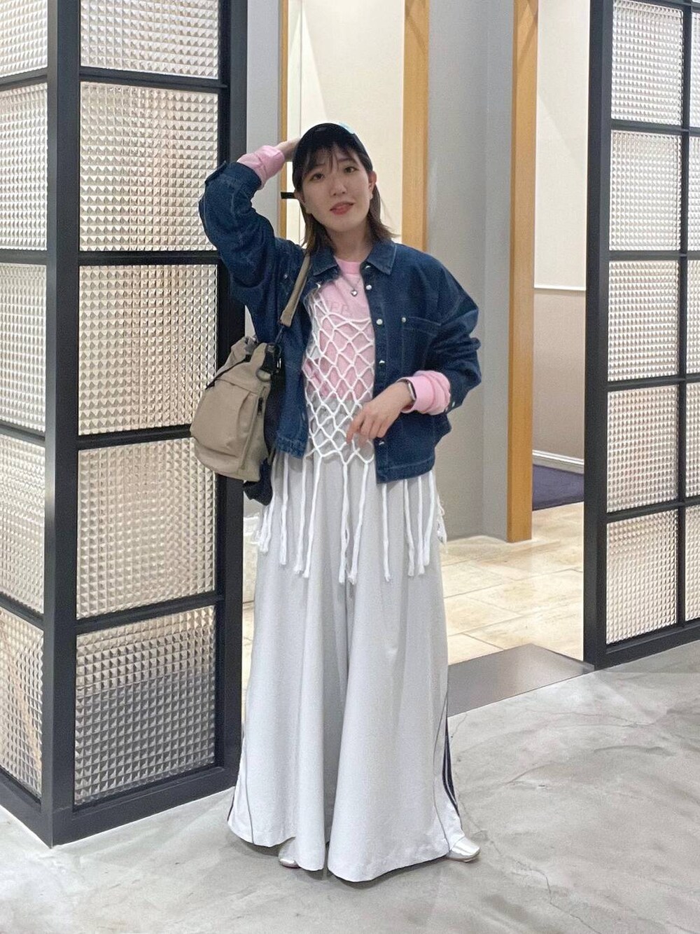 ピンク系のTシャツ/カットソー、ホワイト系のベスト、ベージュ系のショルダーバッグを着用したレディースの春コーディネートの3枚目の写真