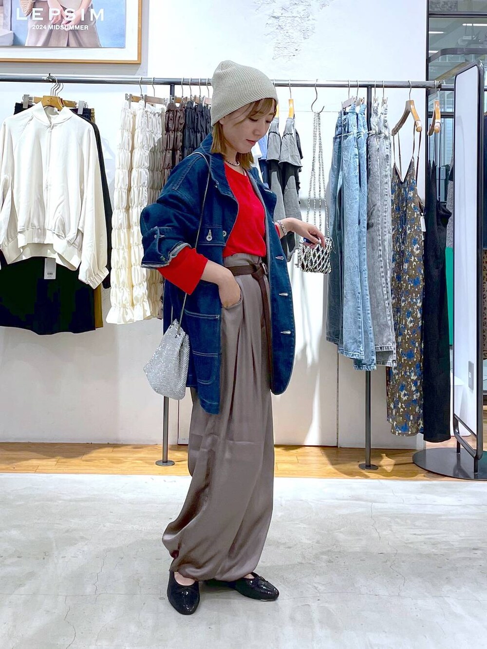 レッド系のTシャツ/カットソー、ブラウン系のその他パンツ、ブルー系のデニムジャケットを着用したレディースの秋コーディネートの2枚目の写真