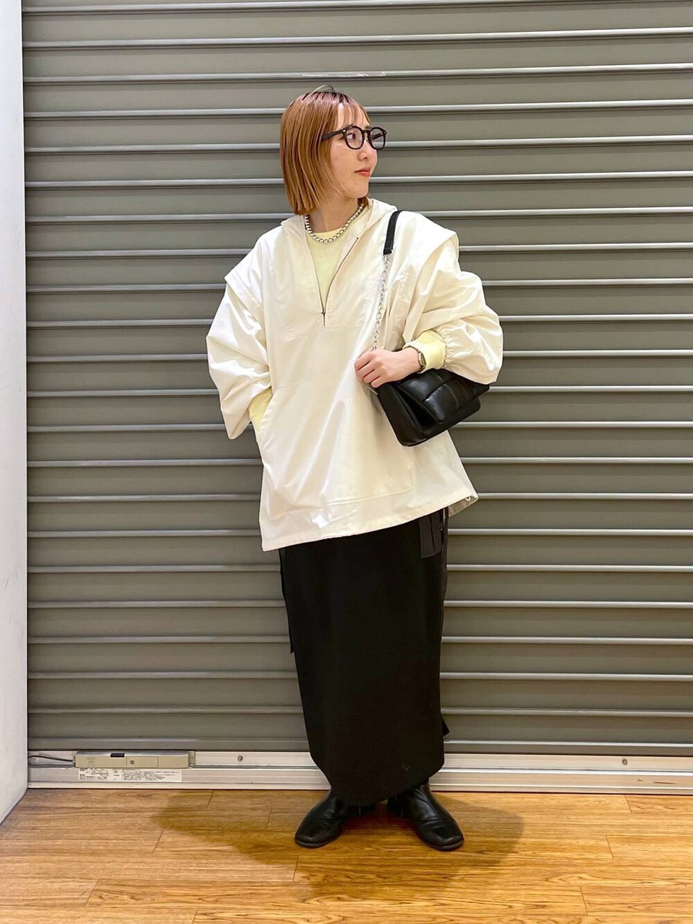 ブラック系のショルダーバッグ、ホワイト系のその他アウター、イエロー系のTシャツ/カットソーを着用したレディースの春コーディネートの4枚目の写真