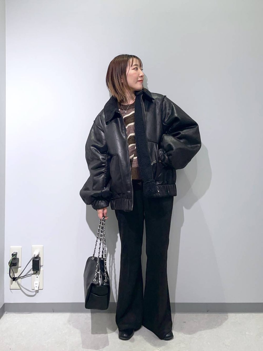ブラウン系のニット/セーター、ブラック系のその他パンツ、ブラック系のブルゾンを着用したレディースの秋コーディネートの2枚目の写真