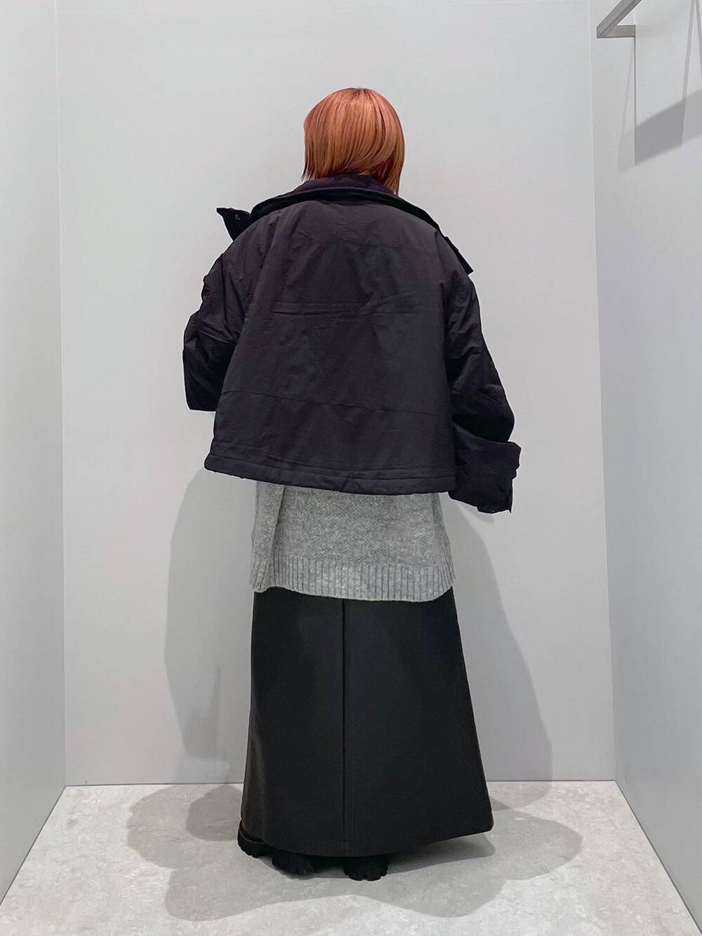 ブラック系のその他アウター、グリーン系のブーツ、グレー系のニット/セーターを着用したレディースの秋コーディネートの3枚目の写真