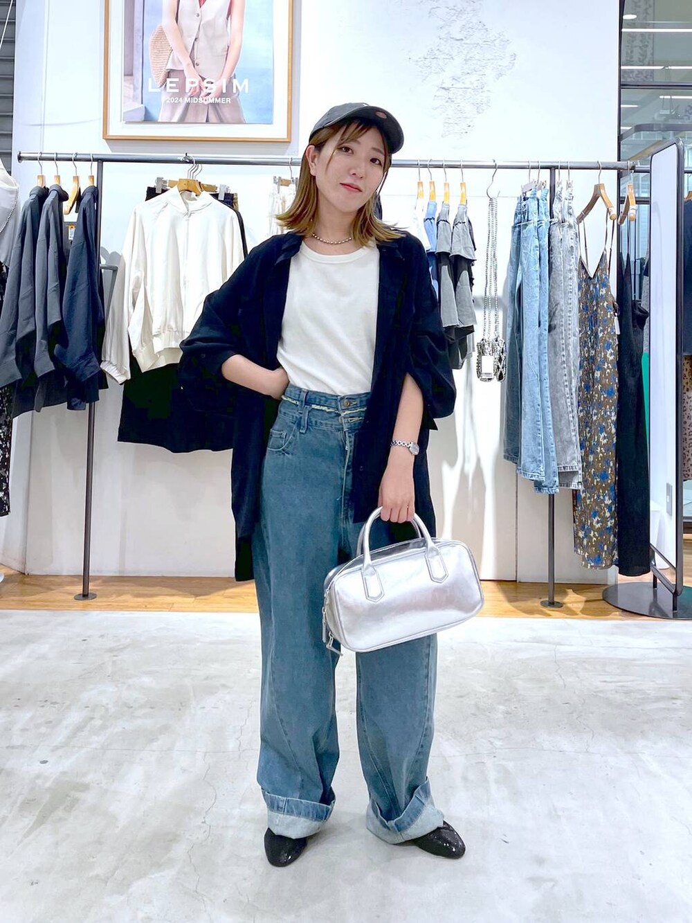 ブルー系のデニムパンツ、シルバー系のボストンバッグ、ブルー系のシャツ/ブラウスを着用したレディースの秋コーディネートの2枚目の写真