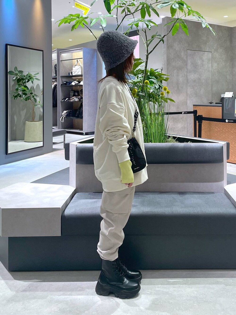 ブラック系のショルダーバッグ、ブラック系のブーツ、ベージュ系のカーゴパンツを着用したレディースの冬コーディネートの4枚目の写真