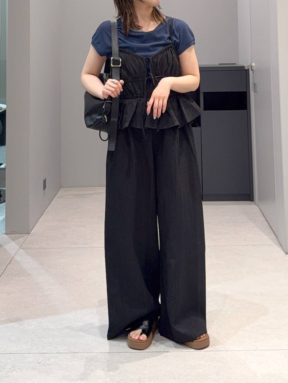 ブルー系のTシャツ/カットソー、ブラック系のサンダル、ブラック系のショルダーバッグを着用したレディースの夏コーディネートの3枚目の写真