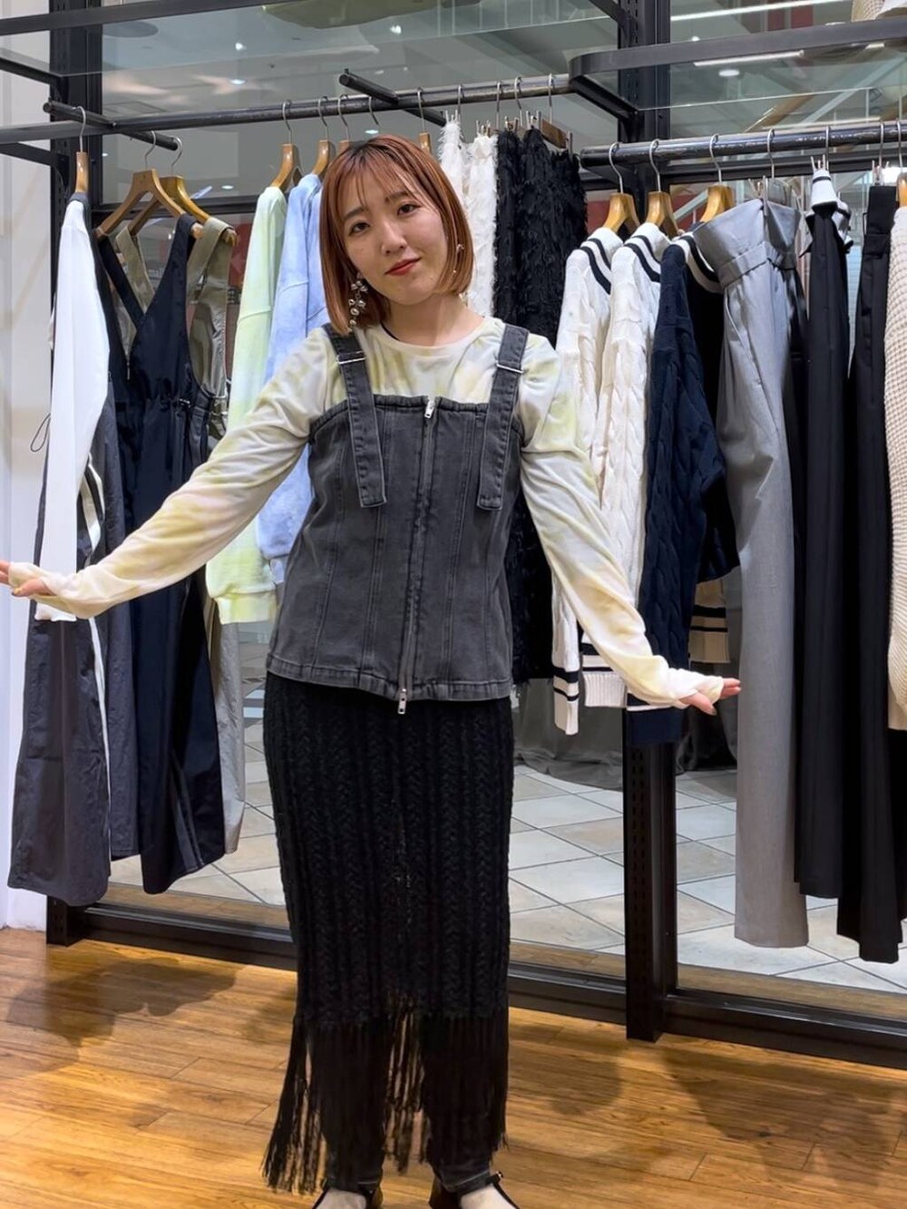 グリーン系のTシャツ/カットソー、ブラック系のベスト、グレー系のデニムパンツを着用したレディースの春コーディネートの2枚目の写真