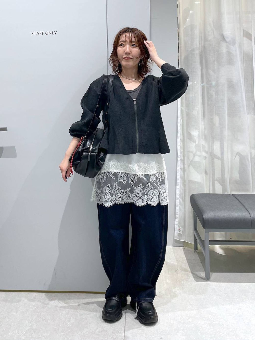 ブルー系のデニムパンツ、ブラック系のボストンバッグ、ブラック系のローファーを着用したレディースの冬コーディネートの5枚目の写真