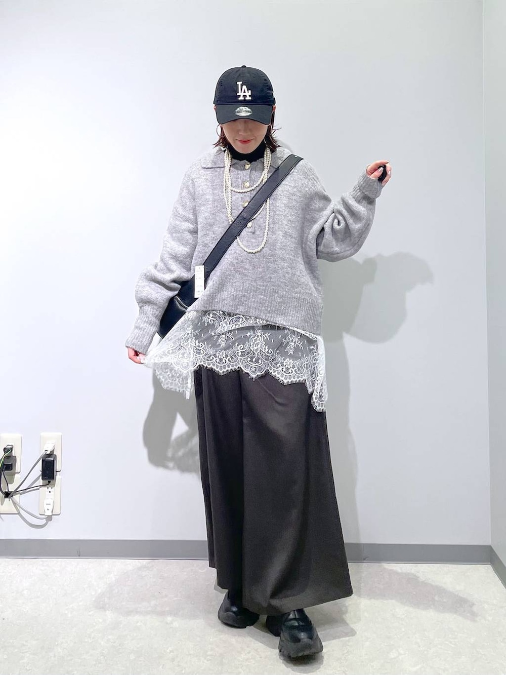 ブラック系のニット/セーター、グレー系のその他パンツ、ホワイト系のTシャツ/カットソーを着用したレディースの冬コーディネートの3枚目の写真