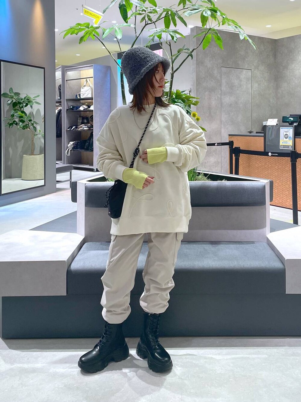 ブラック系のショルダーバッグ、ブラック系のブーツ、ベージュ系のカーゴパンツを着用したレディースの冬コーディネートの6枚目の写真