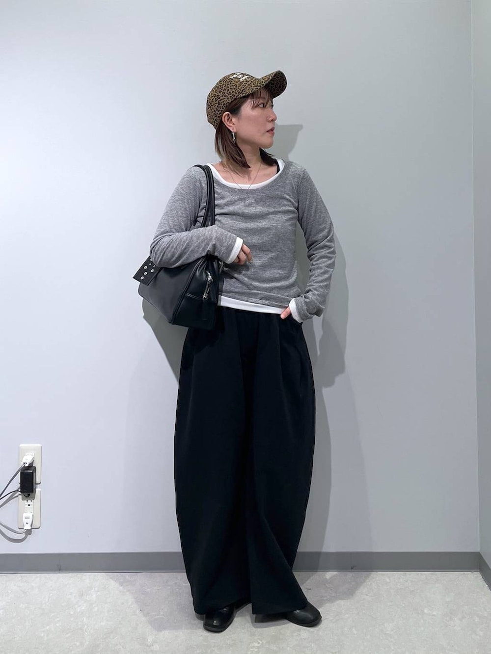 ブラック系のボストンバッグ、ブラック系のスウェットパンツ、グレー系のTシャツ/カットソーを着用したレディースの春コーディネートの2枚目の写真