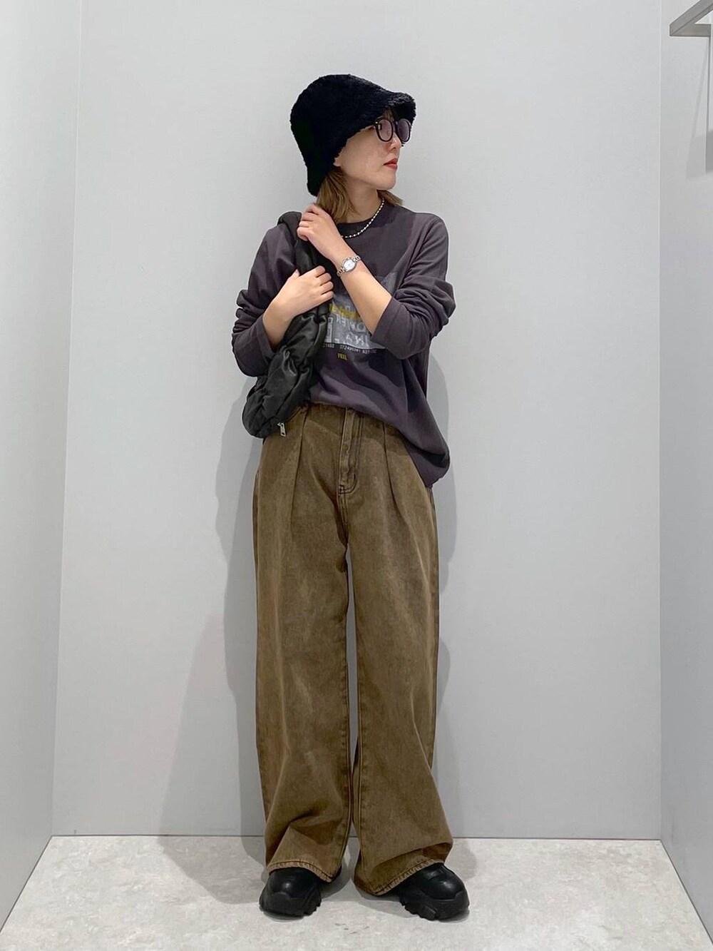ブラック系のハンドバッグ、ブラウン系のデニムパンツ、グレー系のTシャツ/カットソーを着用したレディースの秋コーディネートの3枚目の写真