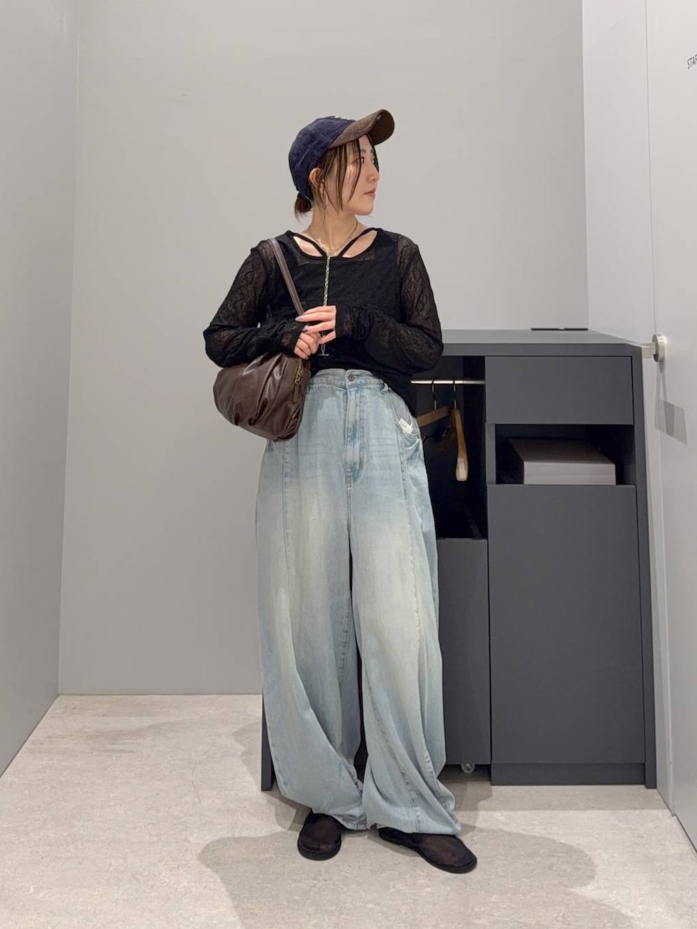 ブラウン系のボストンバッグ、ブラック系のTシャツ/カットソー、ブルー系のデニムパンツを着用したレディースの夏コーディネートの2枚目の写真