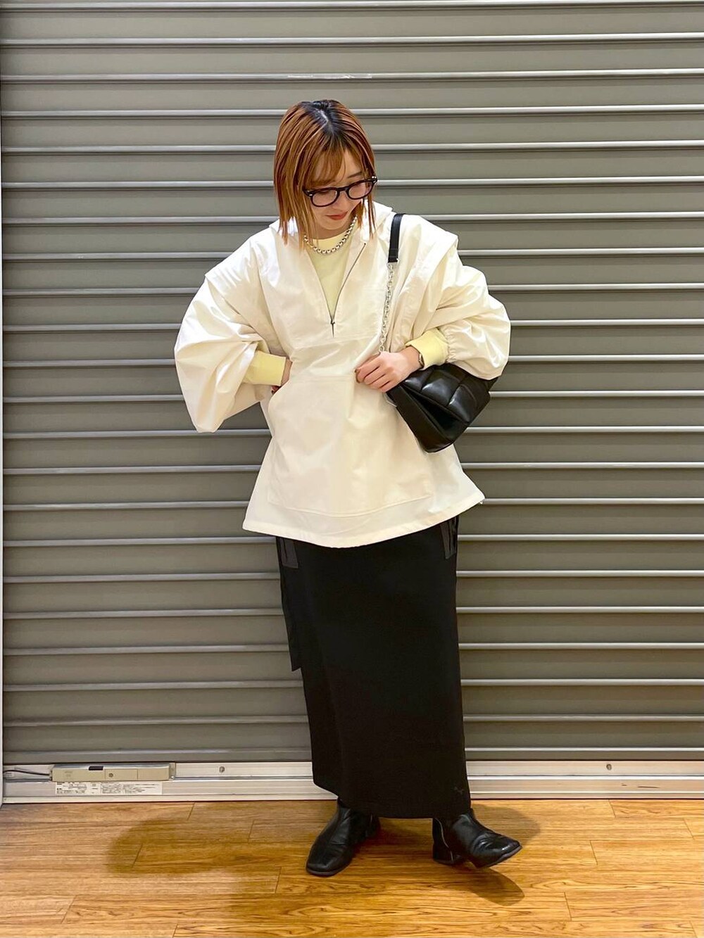 ブラック系のショルダーバッグ、ホワイト系のその他アウター、イエロー系のTシャツ/カットソーを着用したレディースの春コーディネートの2枚目の写真