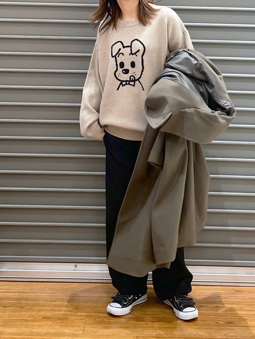 グリーン系のチェスターコート、ブラック系のその他パンツ、ゴールド系のトートバッグを着用したレディースの冬コーディネートの4枚目の写真