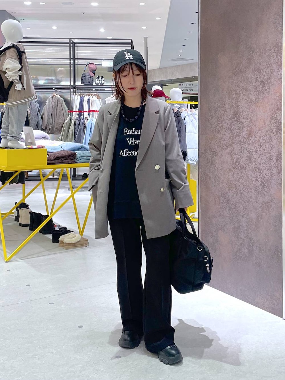 ブラウン系のテーラードジャケット、ブラック系のスウェットパンツ、ブラック系のトートバッグを着用したレディースの冬コーディネートの3枚目の写真